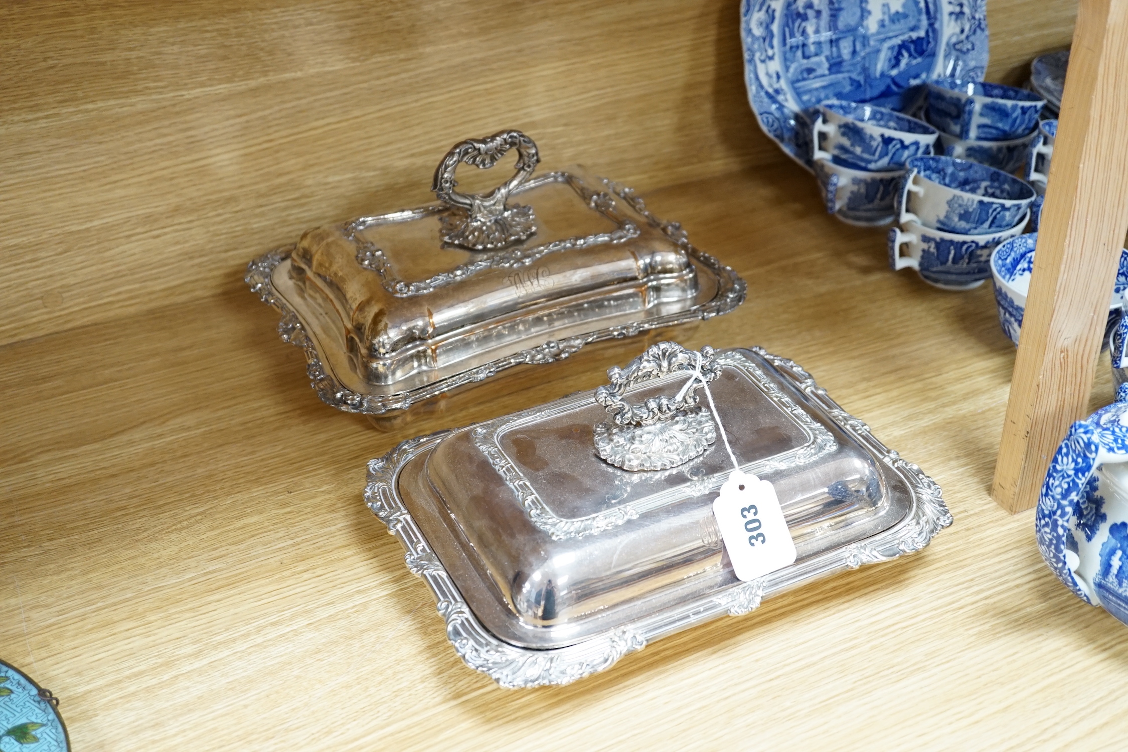 Three plated entree dishes and covers and a pair of candlesticks, candlesticks 26cm high